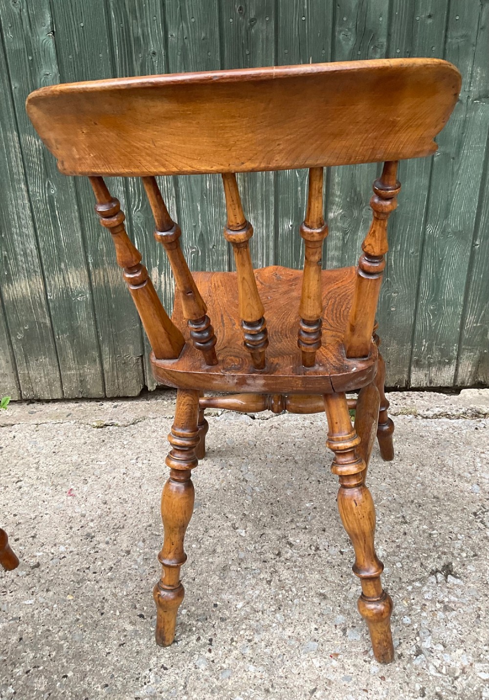 A set of six warm brown wooden dining chairs featuring spindle backrests, contoured wooden seats, and turned legs. View XI