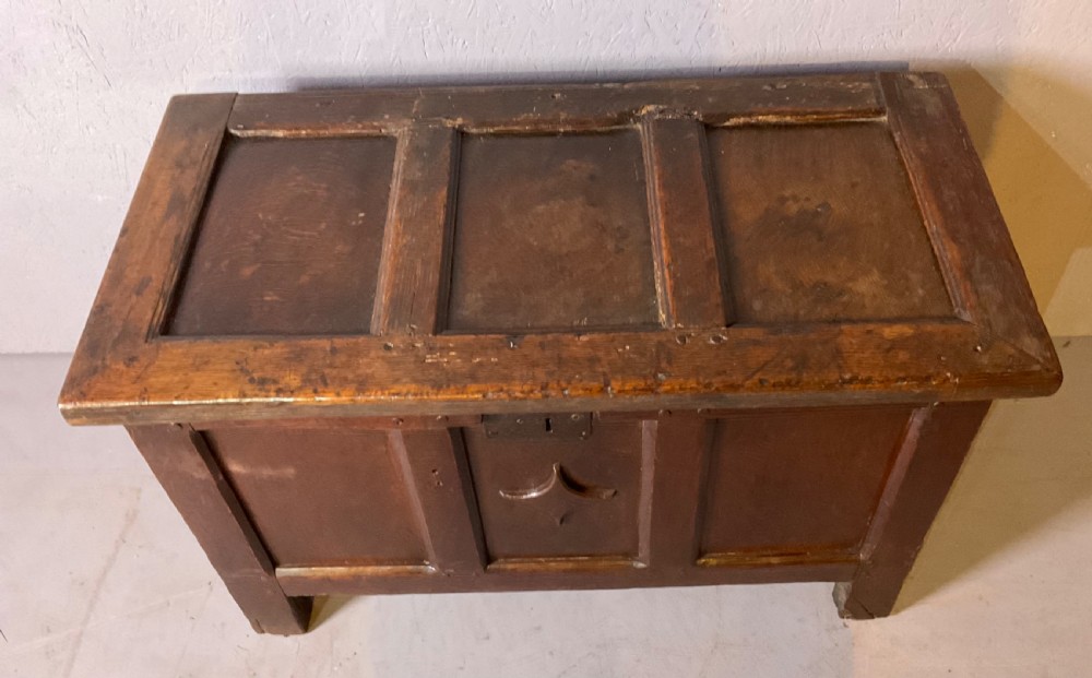 A 17th-century dark oak coffer featuring a three-panel front with a carved central star motif and an iron lockplate. View II
