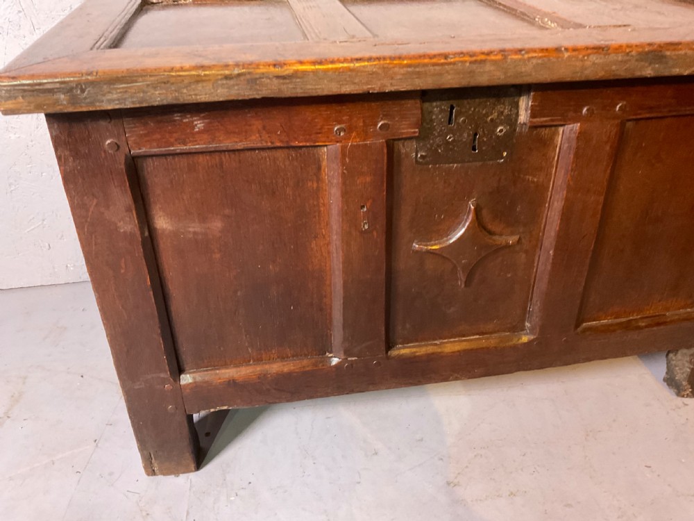 A 17th-century dark oak coffer featuring a three-panel front with a carved central star motif and an iron lockplate. View III