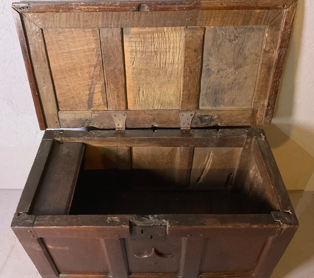 A 17th-century dark oak coffer featuring a three-panel front with a carved central star motif and an iron lockplate. View IV
