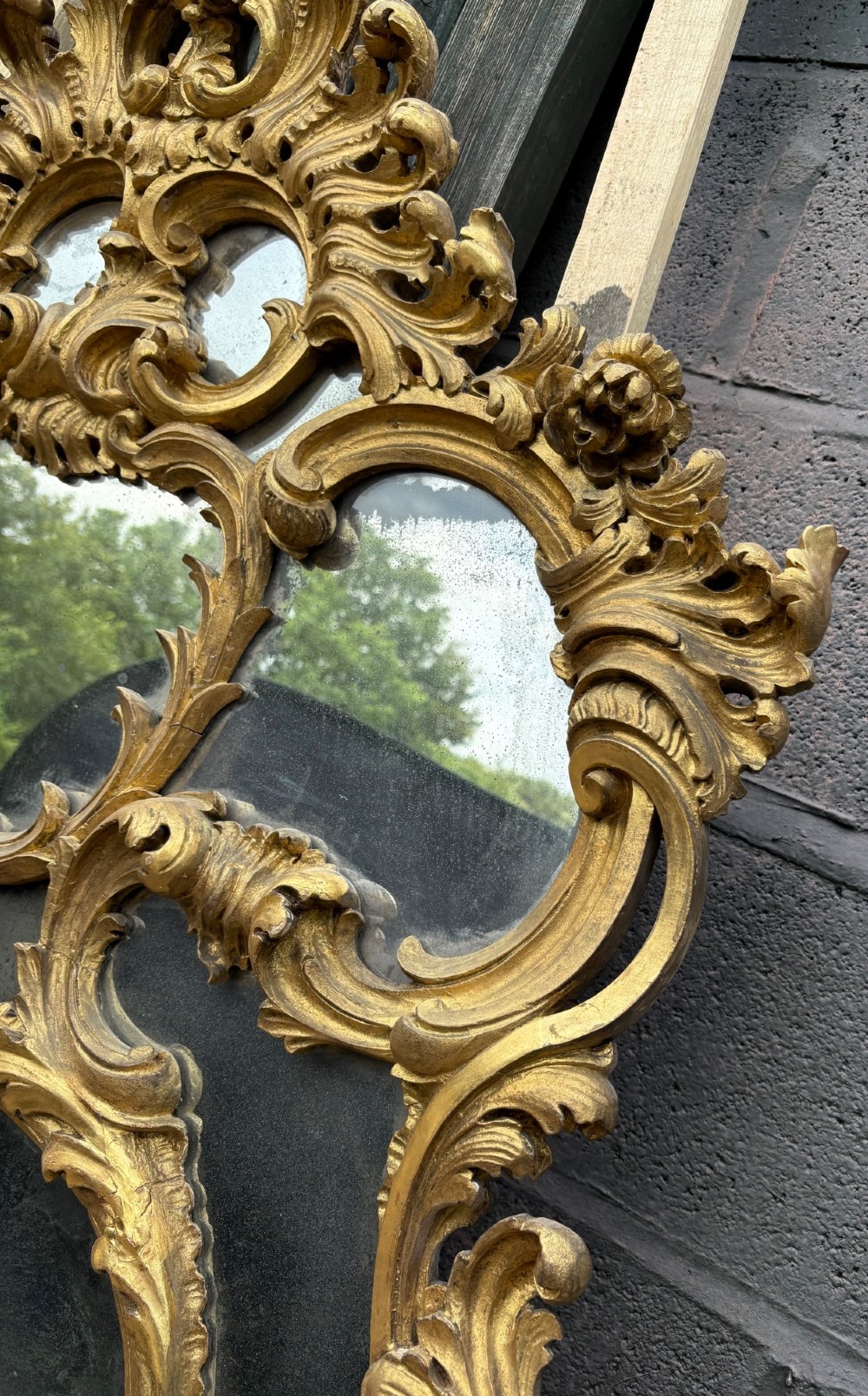 An ornate Georgian Rococo carved giltwood overmantel mirror featuring scrollwork, leaf motifs, and multi-pane glass panels. View VI