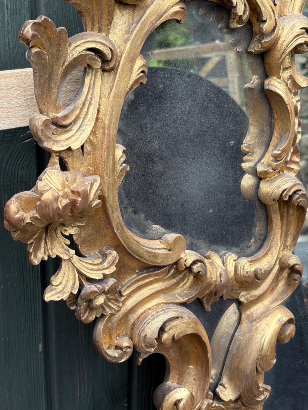 An ornate Georgian Rococo carved giltwood overmantel mirror featuring scrollwork, leaf motifs, and multi-pane glass panels. View XI