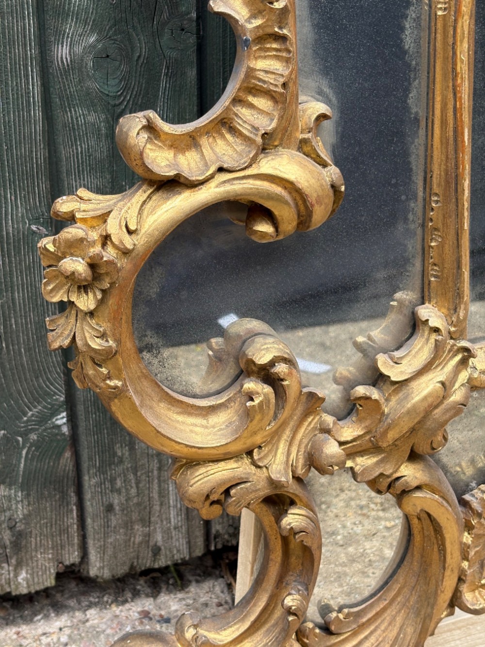 An ornate Georgian Rococo carved giltwood overmantel mirror featuring scrollwork, leaf motifs, and multi-pane glass panels. View XII