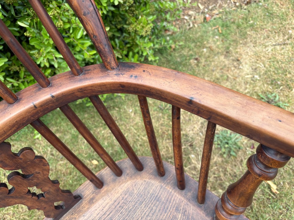 An antique yew wood low-back Windsor armchair featuring a pierced back splat, turned spindles, a contoured seat, and turned legs with a crinoline stretcher. View VII