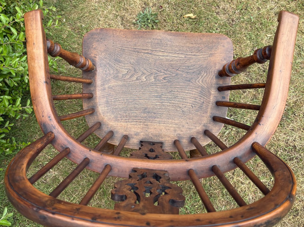An antique yew wood low-back Windsor armchair featuring a pierced back splat, turned spindles, a contoured seat, and turned legs with a crinoline stretcher. View XI