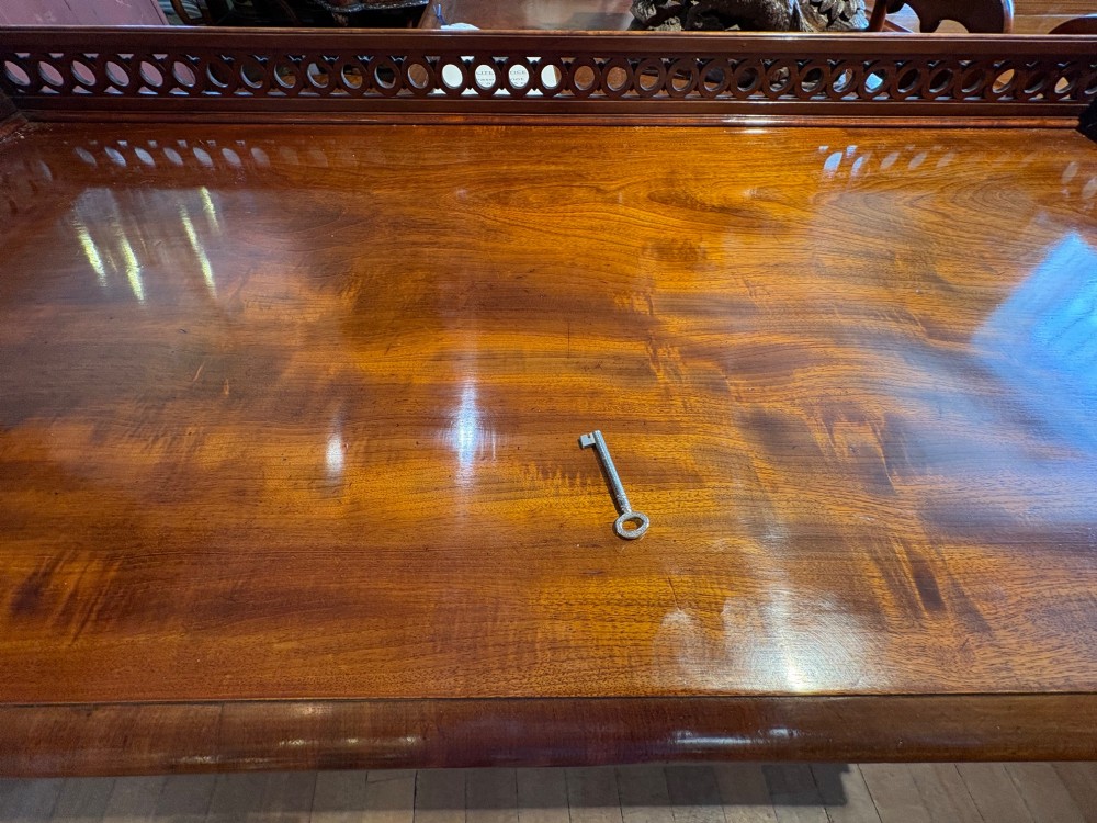 A nineteenth-century mahogany pedestal desk featuring nine drawers with turned wooden handles and a carved pierced gallery top. View VII