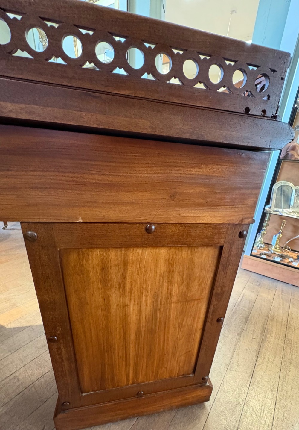 A nineteenth-century mahogany pedestal desk featuring nine drawers with turned wooden handles and a carved pierced gallery top. View X