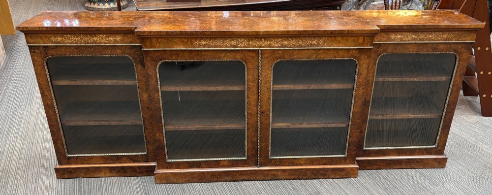 A  Victorian burr walnut and marquetry inlaid low long bookcase