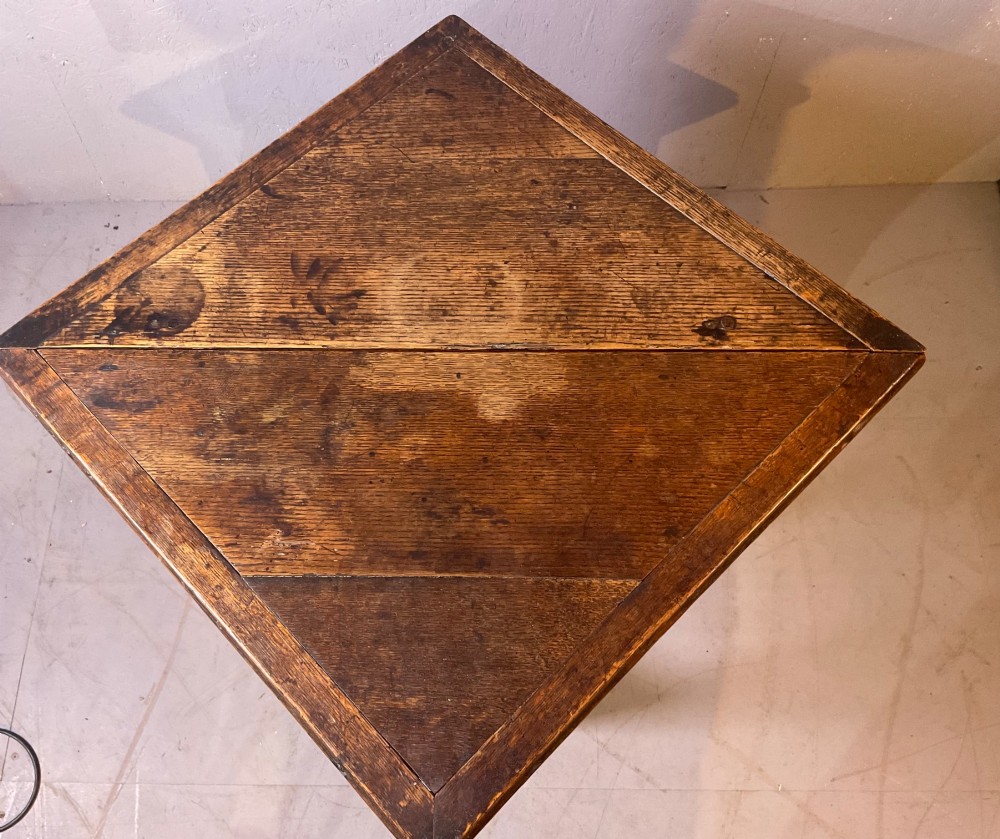 A 17th-century oak credence table featuring a triangular folding top resting on a framework with turned legs and low stretchers. View IV