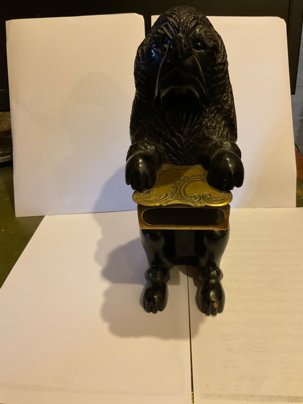 A nineteenth-century carved dark wood match dispenser styled as a begging dog with textured fur and a decorated brass base plate. View II