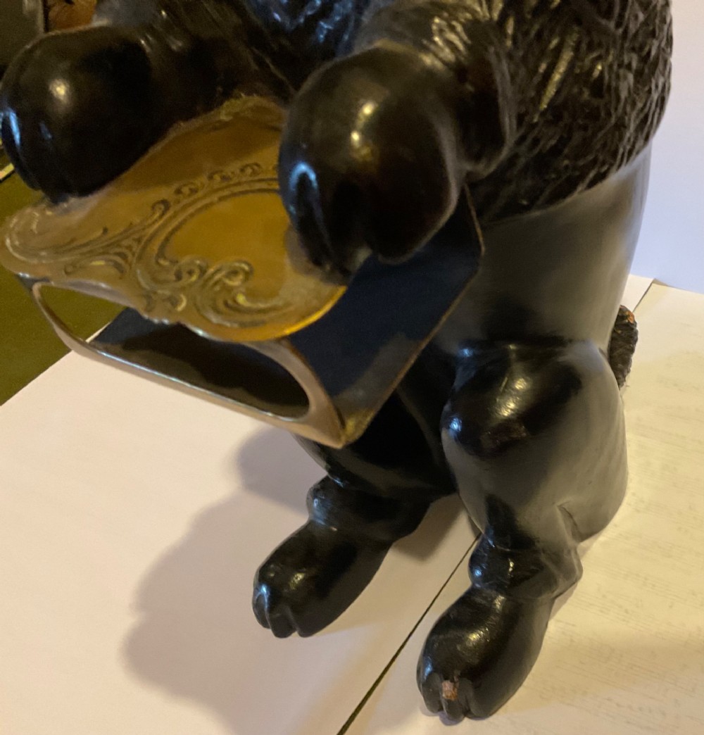 A nineteenth-century carved dark wood match dispenser styled as a begging dog with textured fur and a decorated brass base plate. View VI