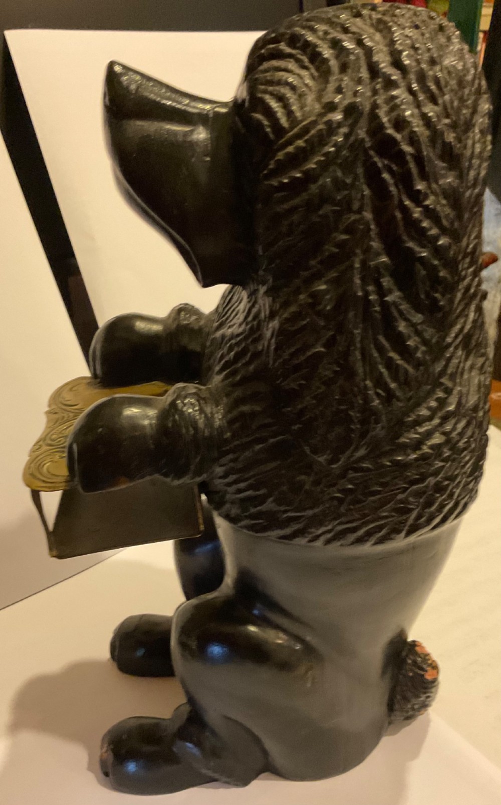 A nineteenth-century carved dark wood match dispenser styled as a begging dog with textured fur and a decorated brass base plate. View VIII
