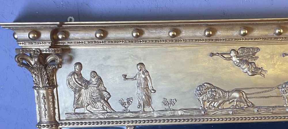 A Victorian gilded gesso overmantel mirror featuring a classical relief frieze above three mirror plates framed by fluted Corinthian columns. View V