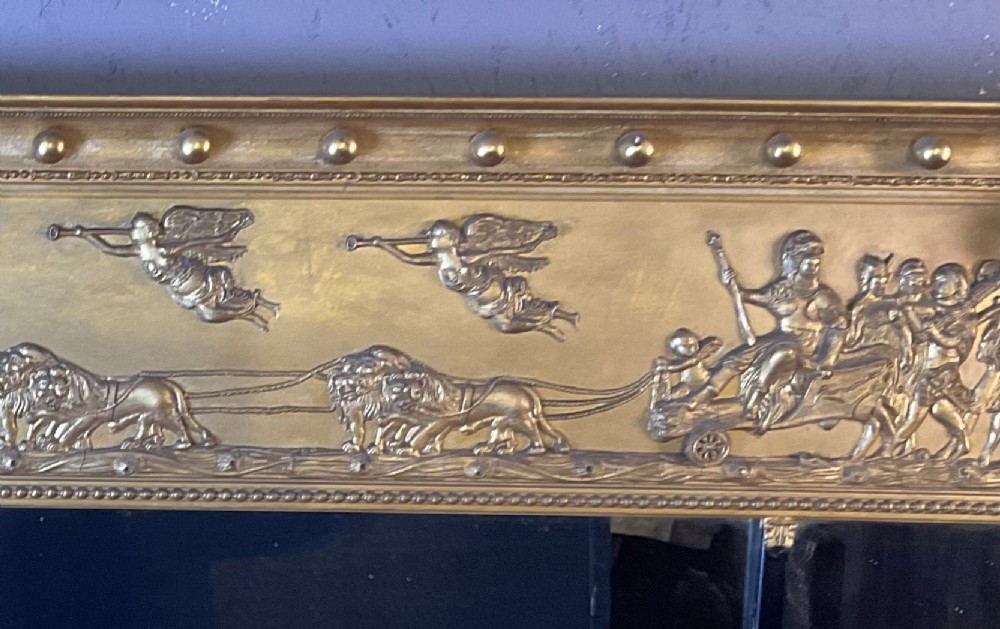 A Victorian gilded gesso overmantel mirror featuring a classical relief frieze above three mirror plates framed by fluted Corinthian columns. View VI