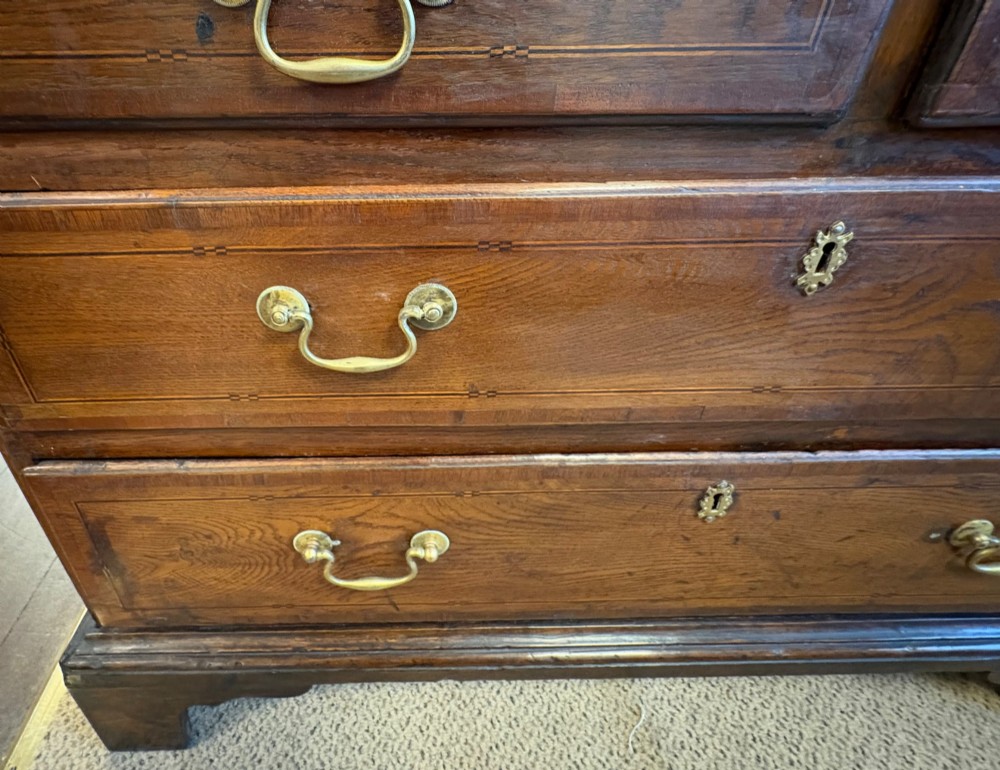 An 18th-century dark oak bureau bookcase featuring an upper cabinet with double panelled doors above a slant-front writing desk and lower drawers with brass handles. View IX