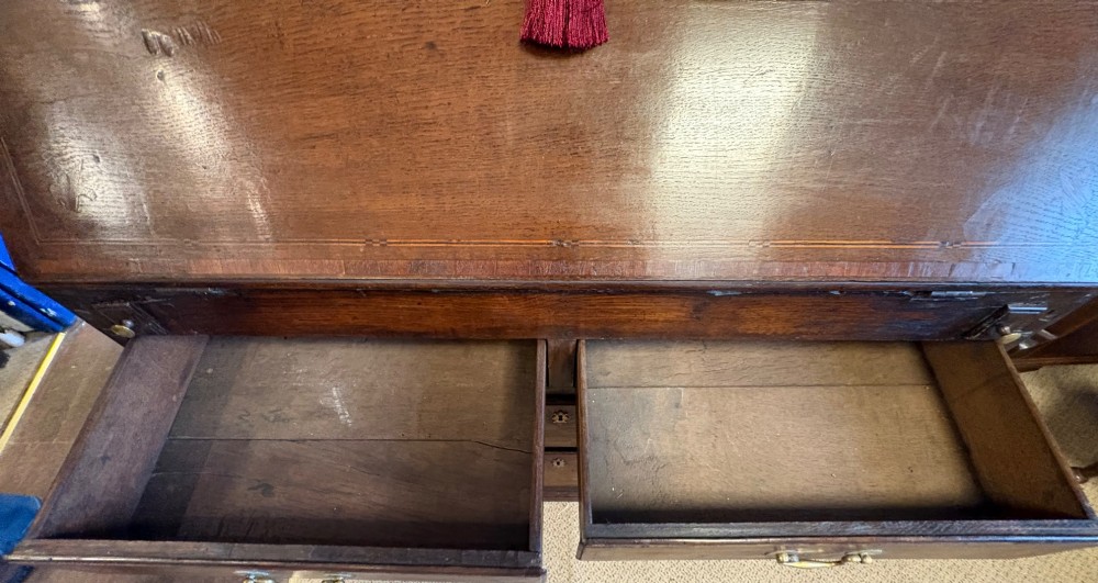 An 18th-century dark oak bureau bookcase featuring an upper cabinet with double panelled doors above a slant-front writing desk and lower drawers with brass handles. View XI