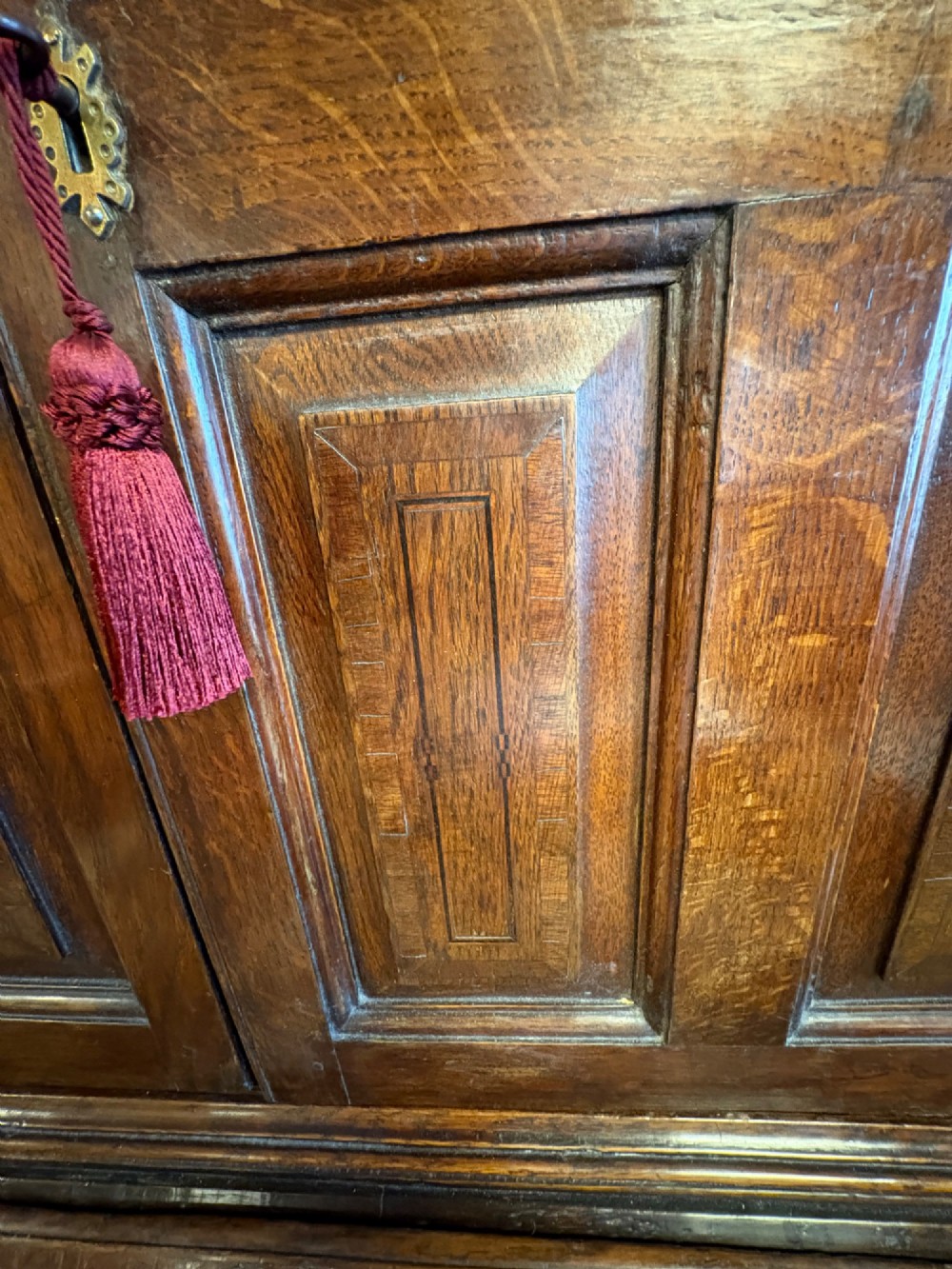 An 18th-century dark oak bureau bookcase featuring an upper cabinet with double panelled doors above a slant-front writing desk and lower drawers with brass handles. View XIII