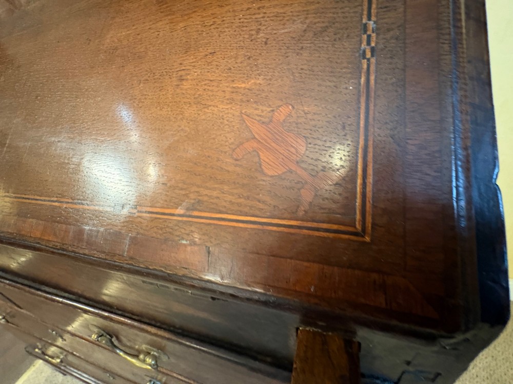 An 18th-century dark oak bureau bookcase featuring an upper cabinet with double panelled doors above a slant-front writing desk and lower drawers with brass handles. View XV