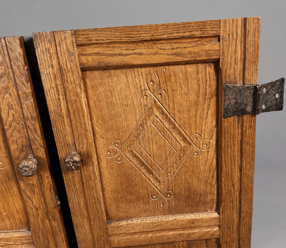 A pair of carved oak cabinet doors featuring double lozenge panel designs, floral knobs, and wrought iron strap hinges. View II