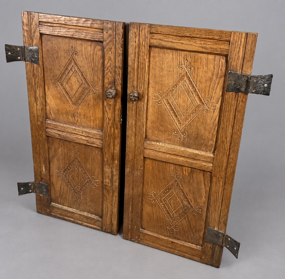 A pair of carved oak cabinet doors featuring double lozenge panel designs, floral knobs, and wrought iron strap hinges. View XI