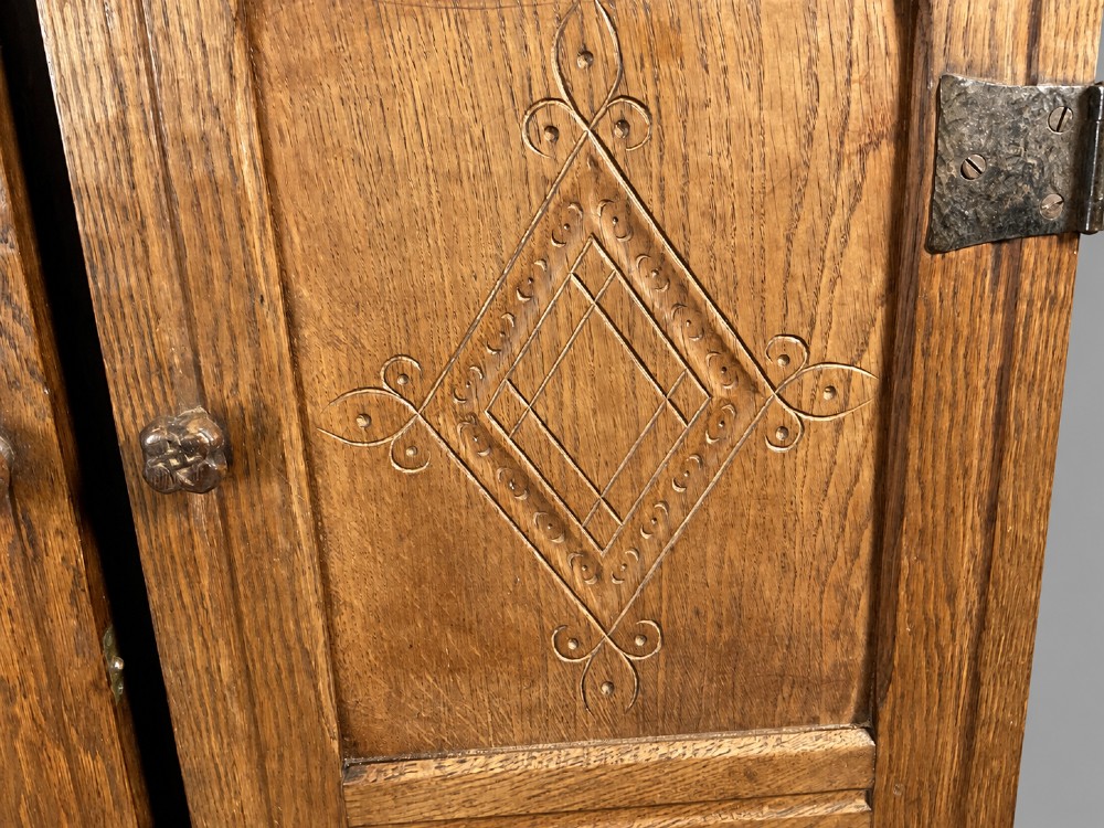 A pair of carved oak cabinet doors featuring double lozenge panel designs, floral knobs, and wrought iron strap hinges. View XIV