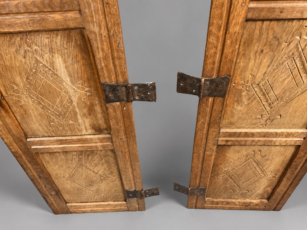 A pair of hand-adzed solid oak cabinet doors featuring three recessed panels with carved diamond motifs and iron strap hinges. View II