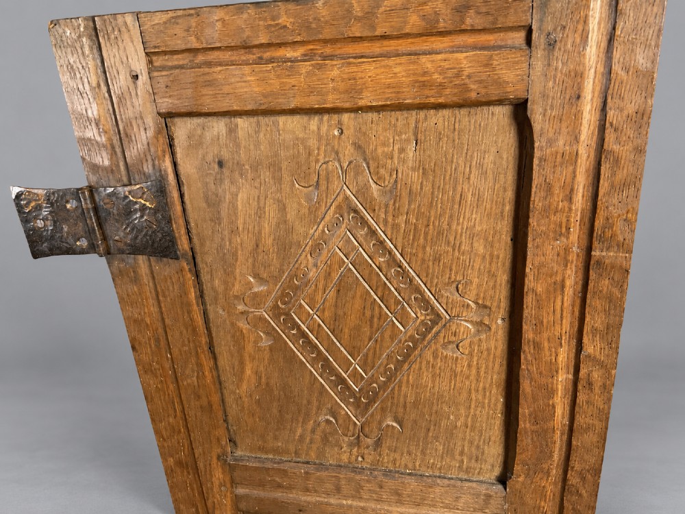 A pair of hand-adzed solid oak cabinet doors featuring three recessed panels with carved diamond motifs and iron strap hinges. View III