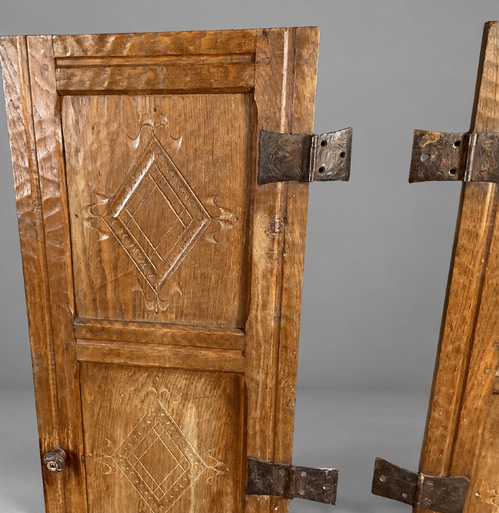 A pair of hand-adzed solid oak cabinet doors featuring three recessed panels with carved diamond motifs and iron strap hinges. View V