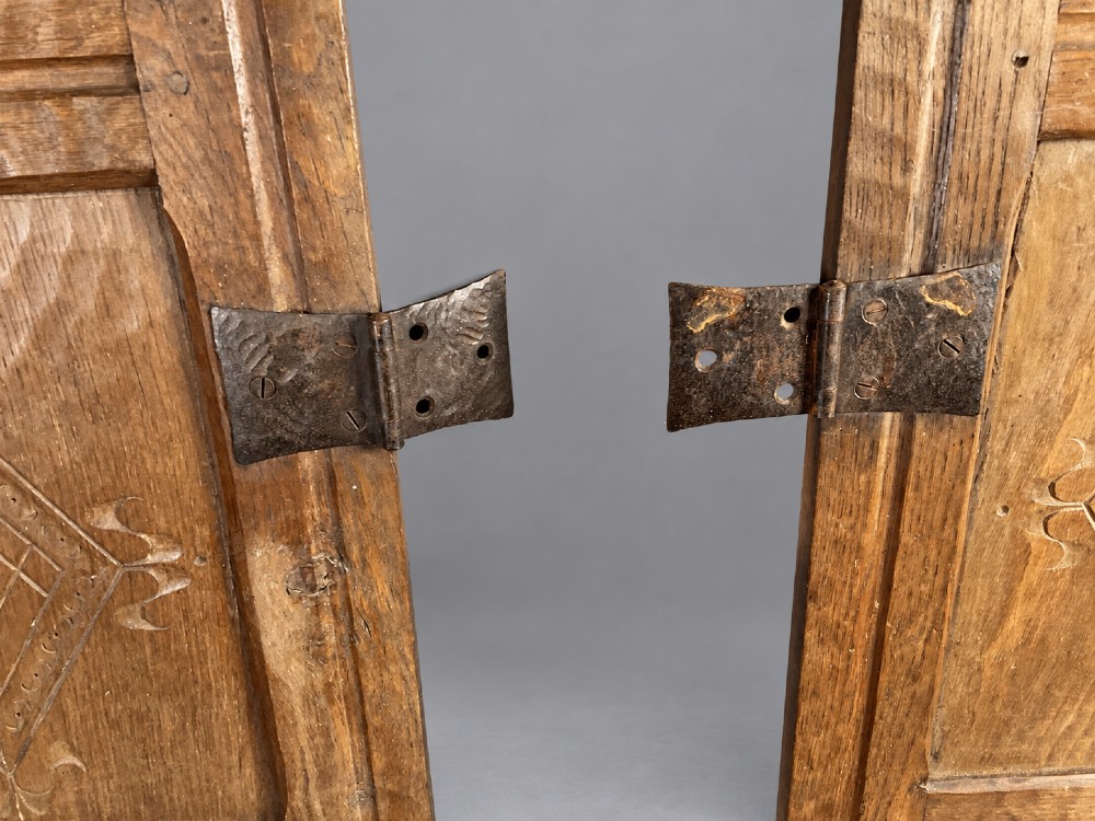 A pair of hand-adzed solid oak cabinet doors featuring three recessed panels with carved diamond motifs and iron strap hinges. View VI