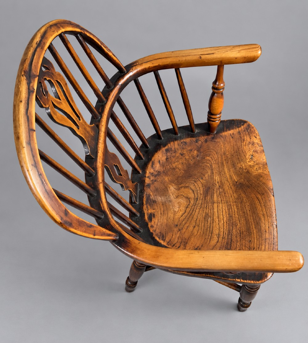 An antique yew wood low-back Windsor armchair featuring a pierced decorative back splat, turned legs, a shaped wooden seat, and a curved crinoline stretcher. View III