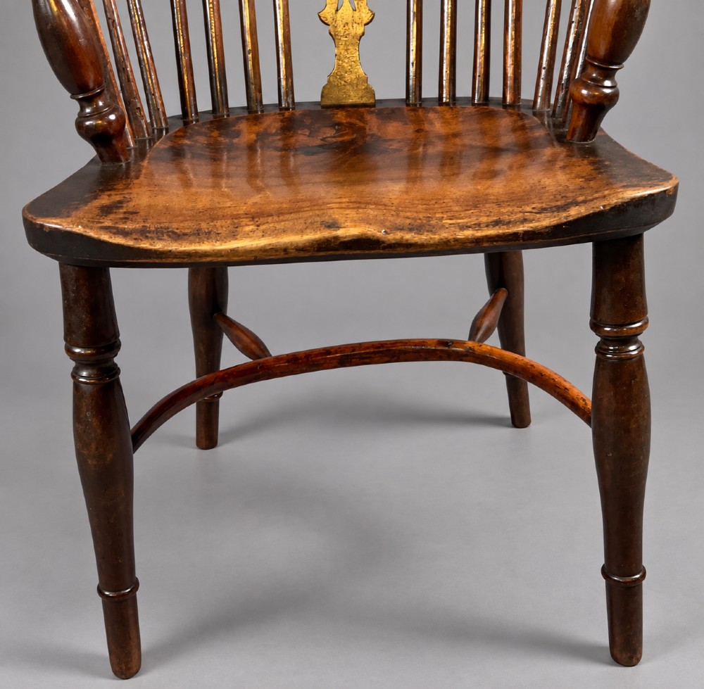 A nineteenth-century high-back yew wood Windsor armchair featuring a pierced back splat, spindled hoop back, shaped elm seat, turned legs, and a crinoline stretcher. View II