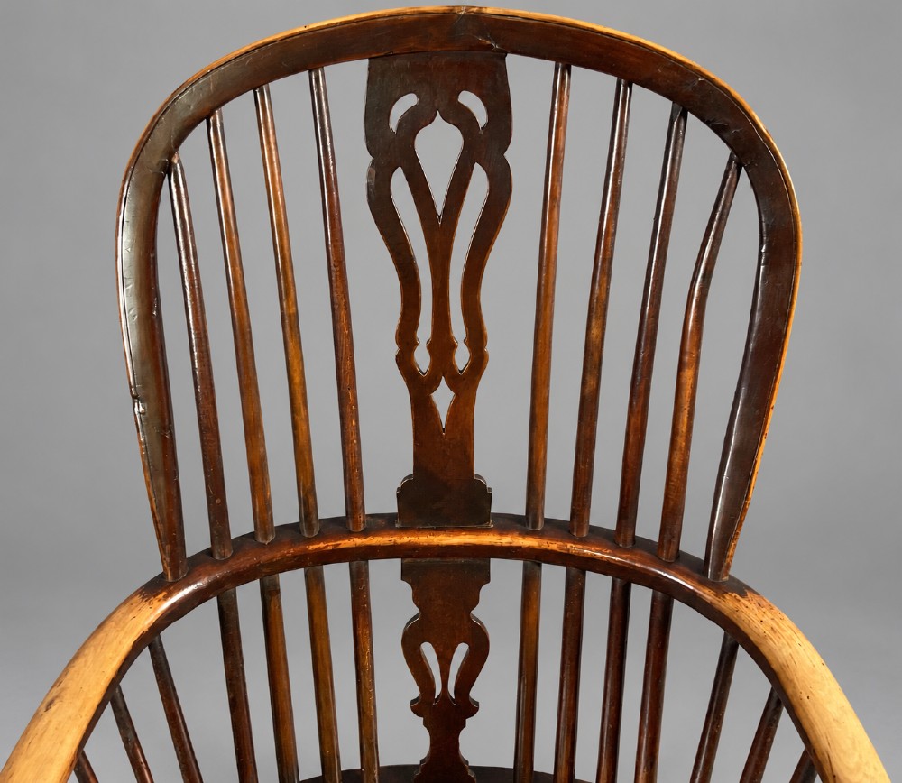 A nineteenth-century high-back yew wood Windsor armchair featuring a pierced back splat, spindled hoop back, shaped elm seat, turned legs, and a crinoline stretcher. View III