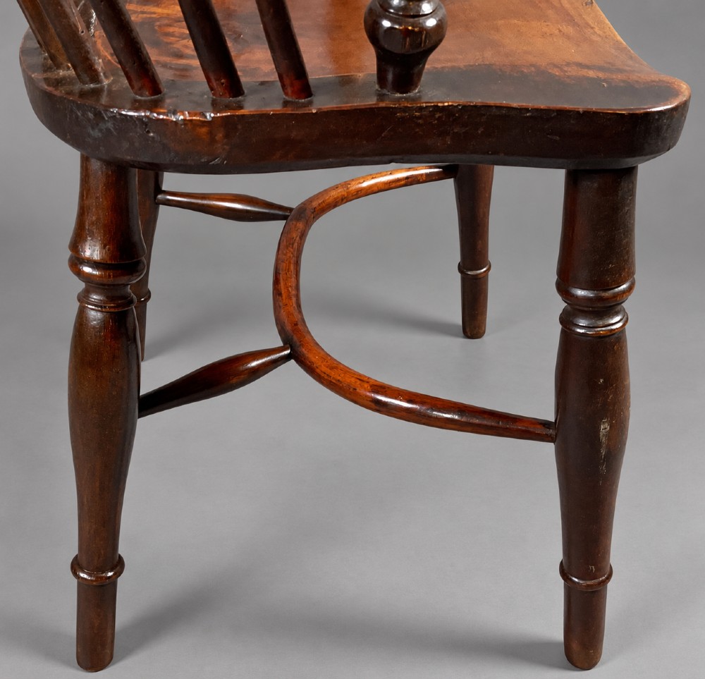 A nineteenth-century high-back yew wood Windsor armchair featuring a pierced back splat, spindled hoop back, shaped elm seat, turned legs, and a crinoline stretcher. View VI