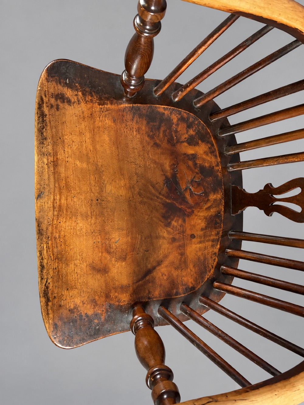 A nineteenth-century high-back yew wood Windsor armchair featuring a pierced back splat, spindled hoop back, shaped elm seat, turned legs, and a crinoline stretcher. View VIII