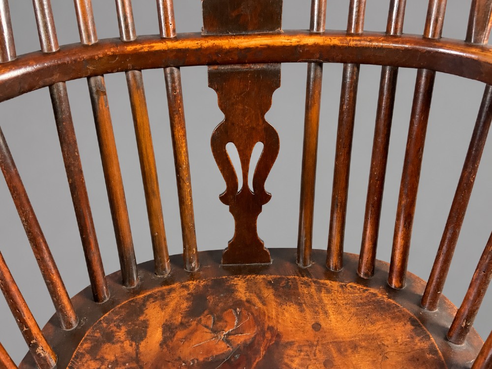 A nineteenth-century high-back yew wood Windsor armchair featuring a pierced back splat, spindled hoop back, shaped elm seat, turned legs, and a crinoline stretcher. View IX