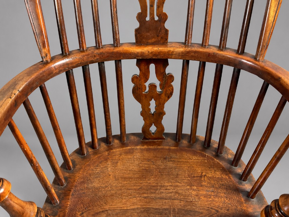 An antique high-back yew wood Windsor armchair featuring turned legs, a shaped seat, and a central pierced fretwork splat. View V