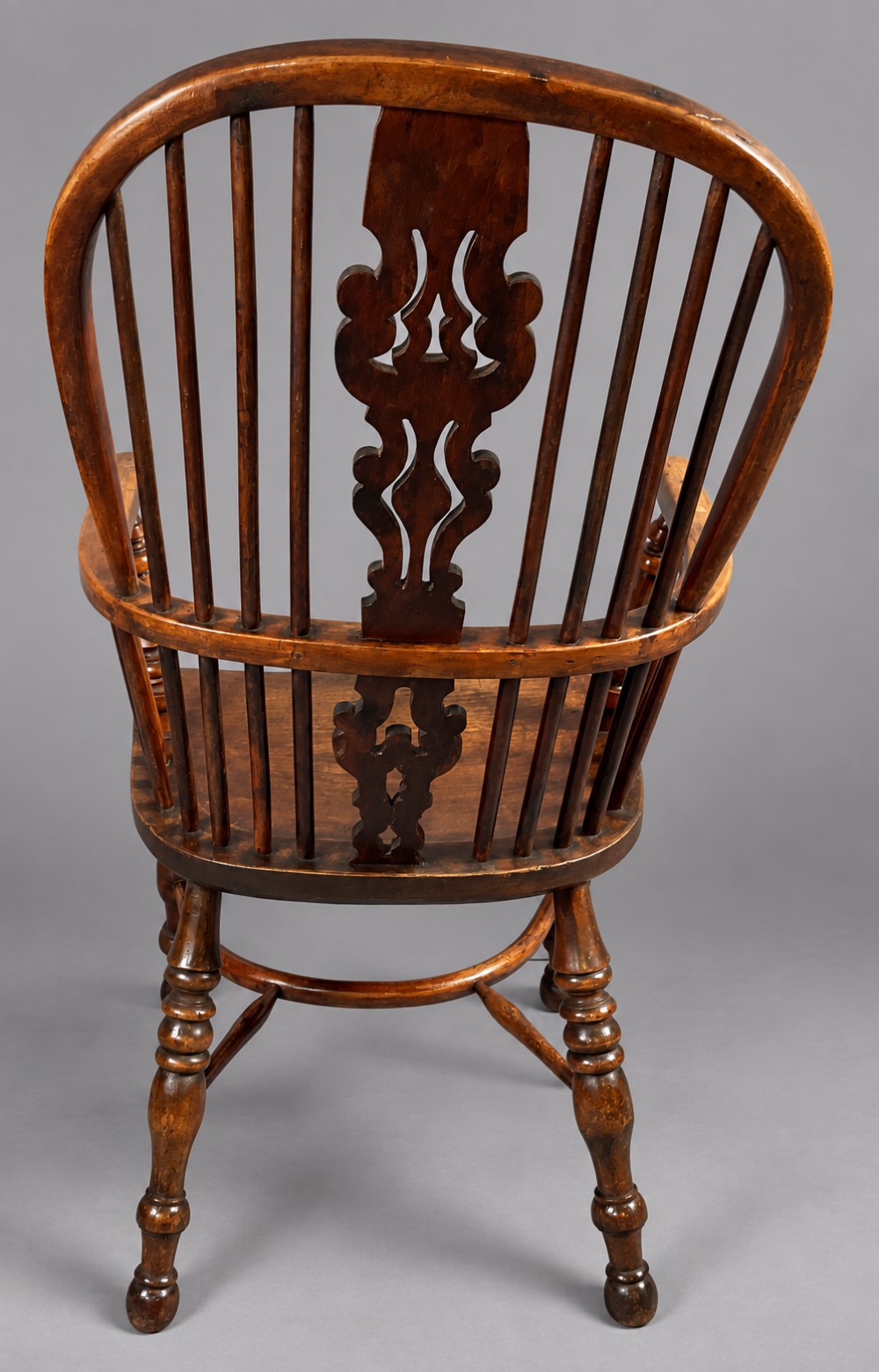 An antique high-back yew wood Windsor armchair featuring turned legs, a shaped seat, and a central pierced fretwork splat. View IX