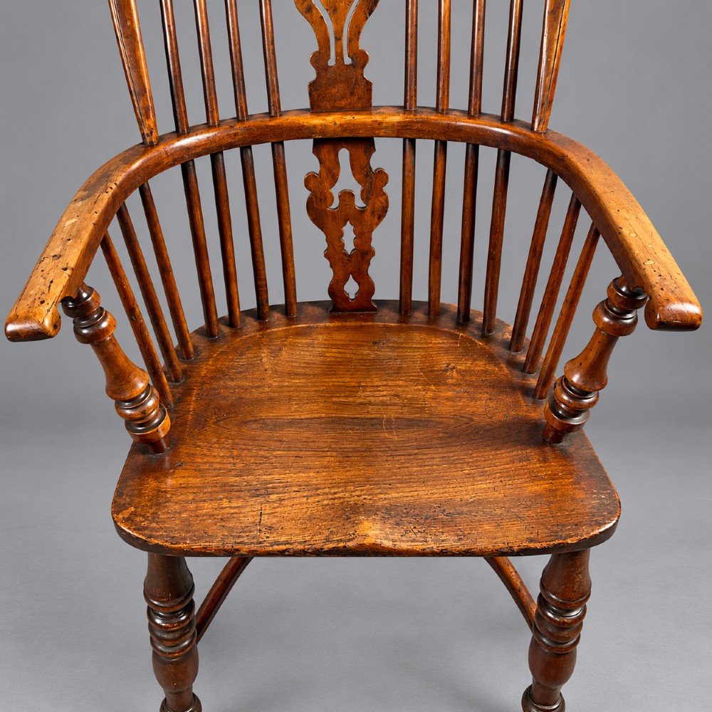 An antique high-back yew wood Windsor armchair featuring turned legs, a shaped seat, and a central pierced fretwork splat. View X