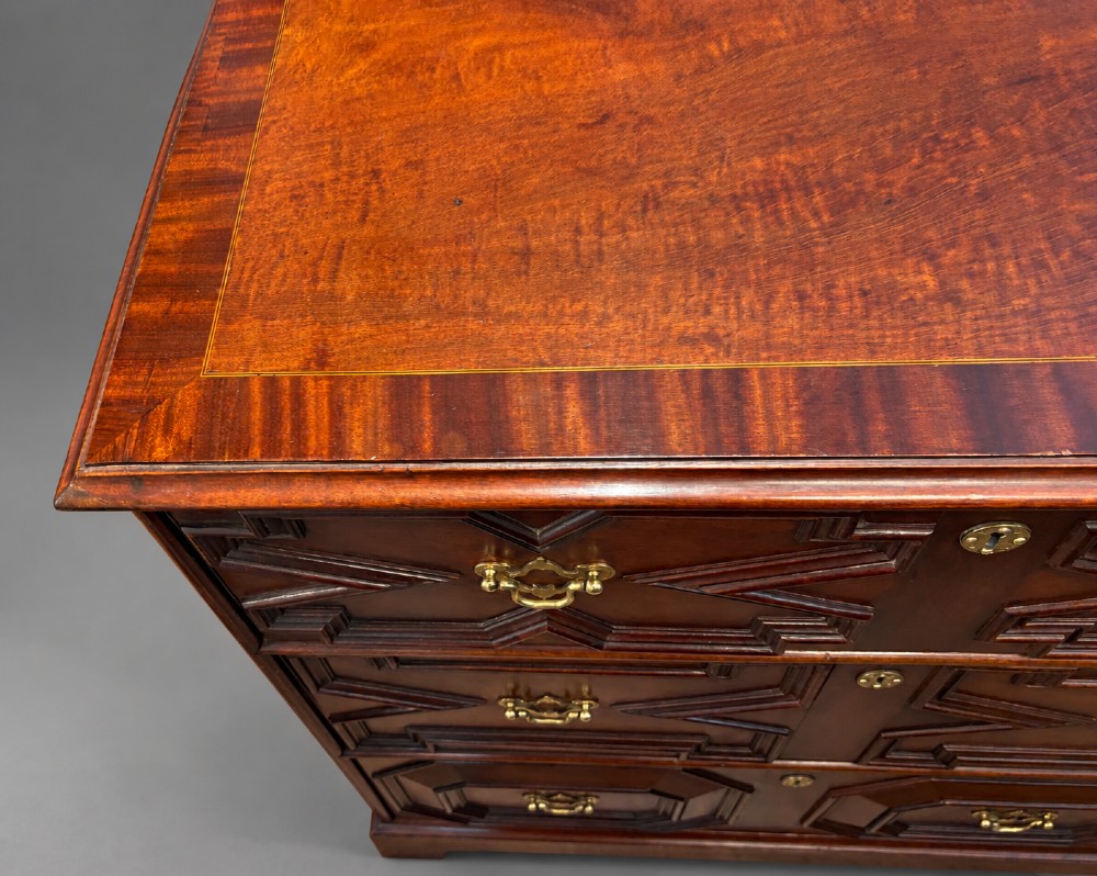 An 18th-century mahogany chest of drawers featuring geometric mitred mouldings, cast brass swan-neck handles, keyhole escutcheons, and bracket feet. View II