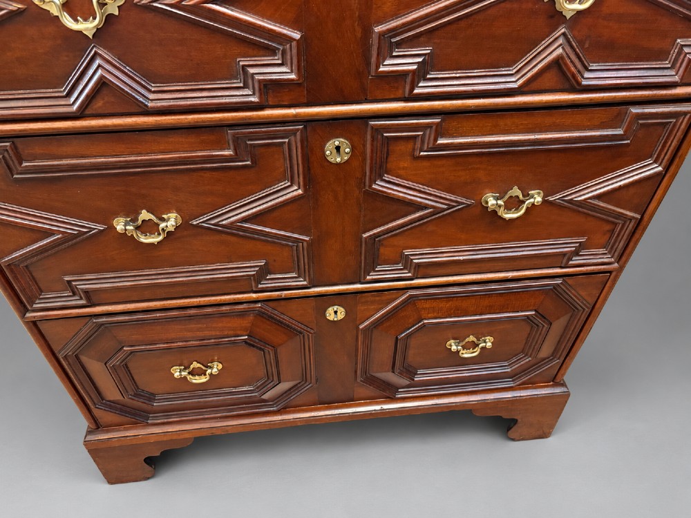 An 18th-century mahogany chest of drawers featuring geometric mitred mouldings, cast brass swan-neck handles, keyhole escutcheons, and bracket feet. View VI