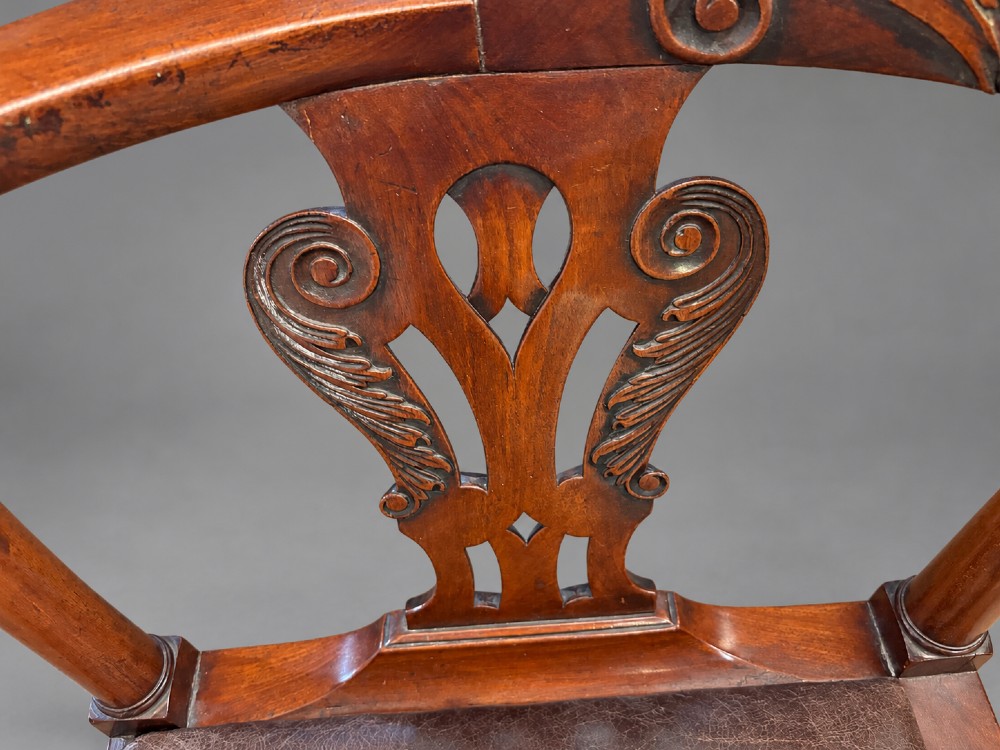 An 18th century Georgian mahogany corner chair featuring carved back splats, scrolled arms, a dark leather seat, and cabriole legs with ball and claw feet. View IV