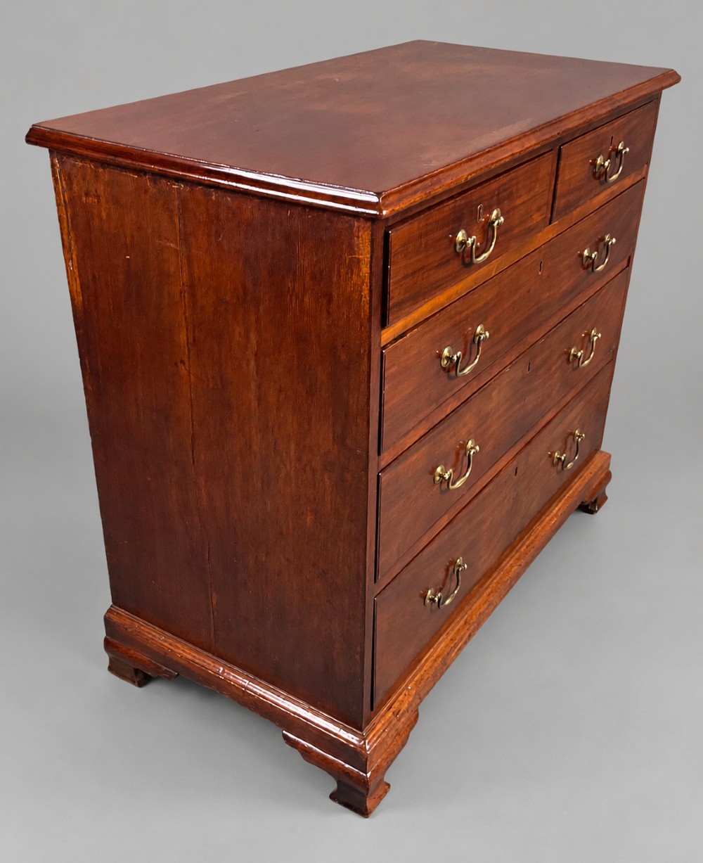 A Georgian mahogany chest of drawers featuring two short drawers over three long graduated drawers with brass swan-neck handles and bracket feet. View VI