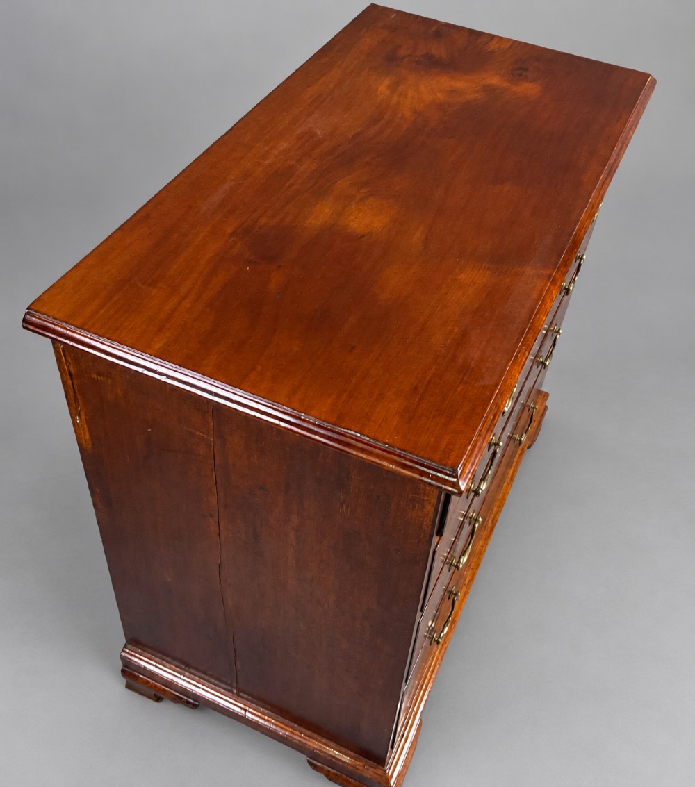 A Georgian mahogany chest of drawers featuring two short drawers over three long graduated drawers with brass swan-neck handles and bracket feet. View VII