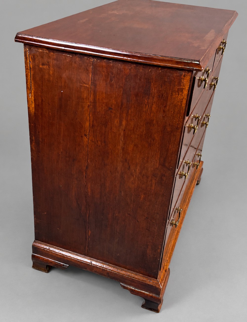 A Georgian mahogany chest of drawers featuring two short drawers over three long graduated drawers with brass swan-neck handles and bracket feet. View VIII
