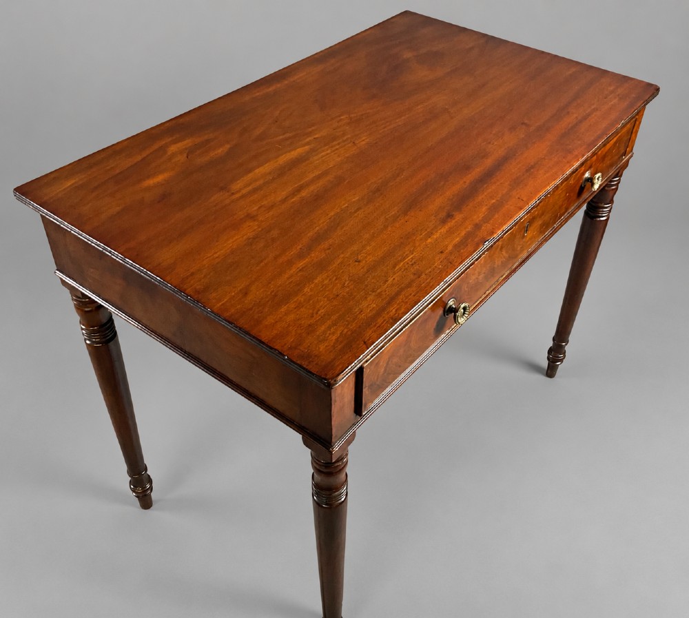 A rectangular mahogany library table featuring a single frieze drawer with brass handles and turned tapered legs. View II