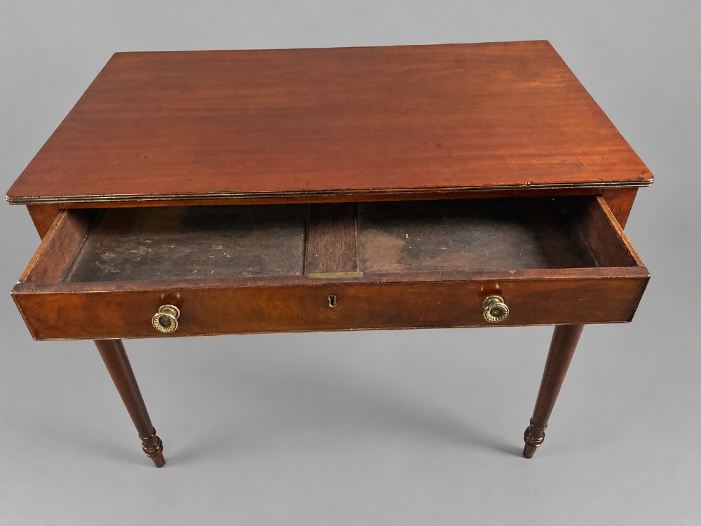 A rectangular mahogany library table featuring a single frieze drawer with brass handles and turned tapered legs. View III