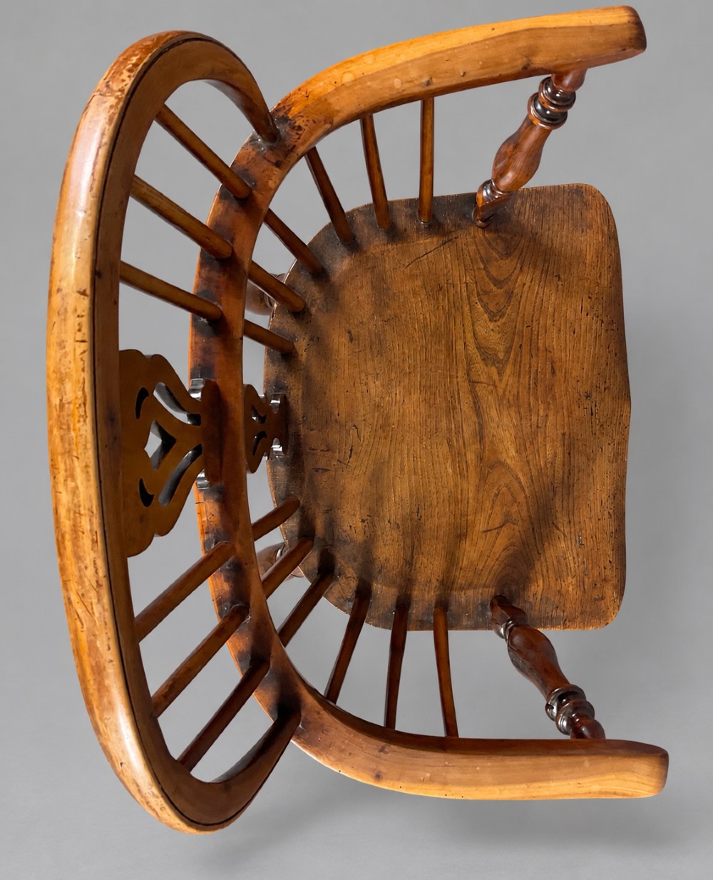 A low back antique yew wood Windsor chair featuring a contoured seat, turned legs, a crinoline stretcher, and a pierced decorative splat. View V