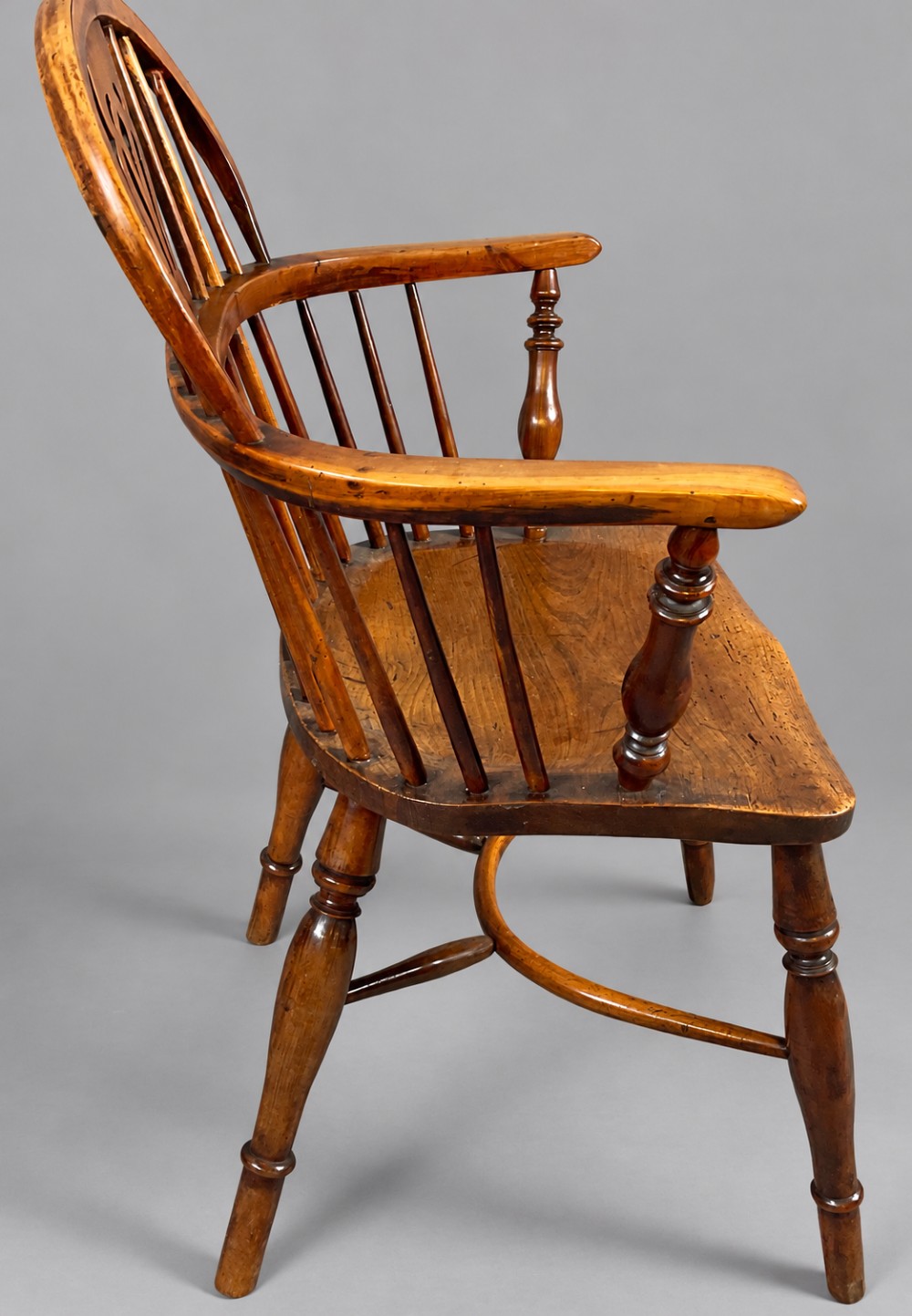 A low back antique yew wood Windsor chair featuring a contoured seat, turned legs, a crinoline stretcher, and a pierced decorative splat. View VI