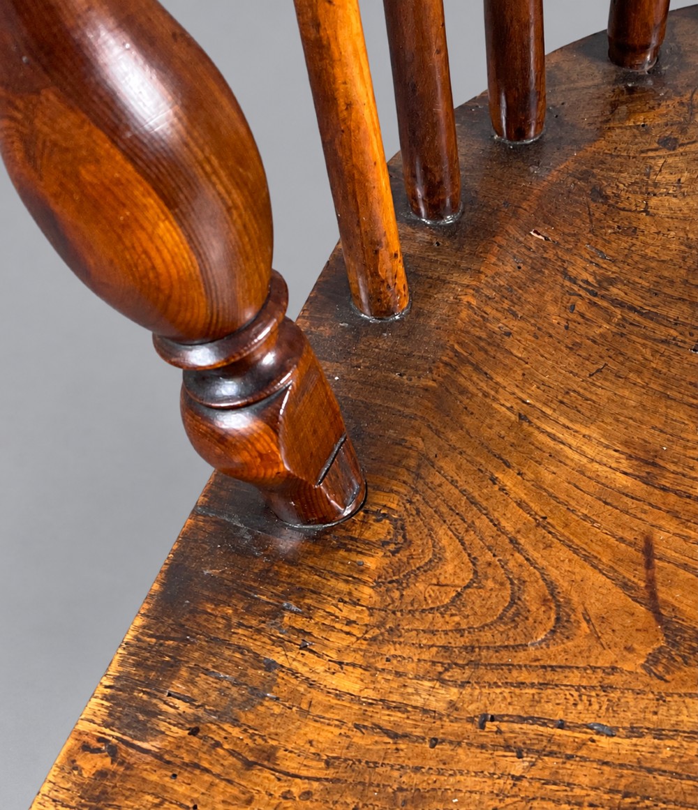 A low back antique yew wood Windsor chair featuring a contoured seat, turned legs, a crinoline stretcher, and a pierced decorative splat. View X