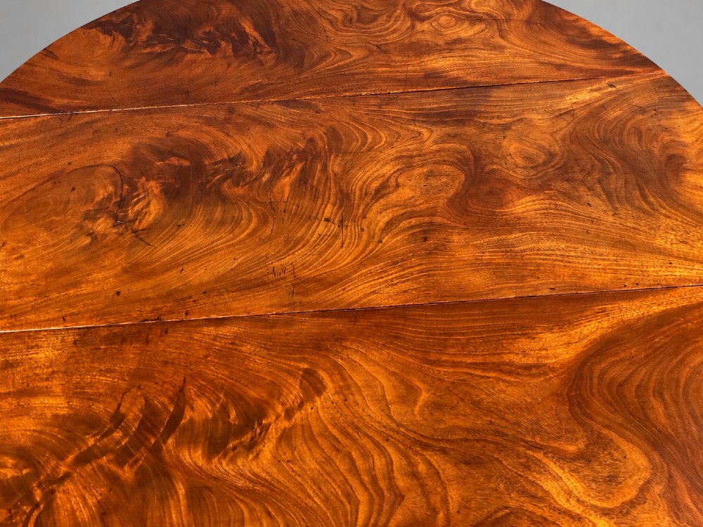 An 18th-century Georgian mahogany drop-leaf table featuring an oval top with rich grain figure and tapered legs ending in pad feet. View III